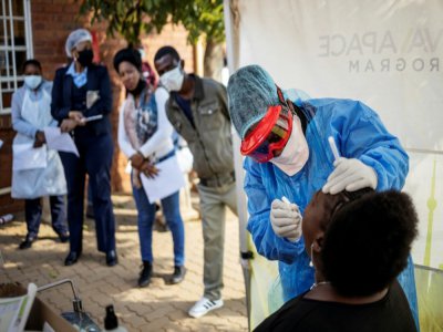 Un mÃ©decin effectue un prÃ©lÃ¨vement sur une femme pour un test au Covid-19, le 13 mai 2020 Ã  Johannesburg, en Afrique du Sud - Michele Spatari [AFP/Archives]