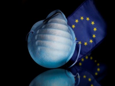 Un masque de protection contre le coronavirus devant un drapeau de l'Union européenne, le 27 février 2020 à Bruxelles - Kenzo TRIBOUILLARD [AFP]