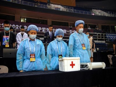 Du personnel soignant rend hommages aux morts du coronavirus avant un match de basketball à Qingdao, le 20 juin 2020 - STR [AFP]