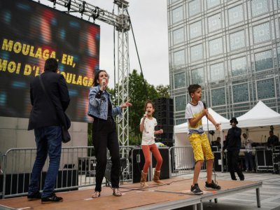 Une artiste et des enfants chantent sur scène lors de la Fête de la musique, le 21 juin 2020 à l'Institut du monde arabe à Paris - ABDULMONAM EASSA [AFP]