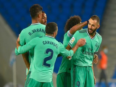 L'attaquant français du Real Madrid, Karim Benzema (d), félicité par ses coéquipiers après son but lors du match de Liga face à la Real Sociedad, à San Sebastian, le 21 juin 2020 - ANDER GILLENEA [AFP]
