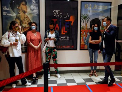 Des spectateurs attendent la première séance après la réouverture dans un cinéma de Paris, dans la nuit du 21 au 22 juin 2020 - Abdulmonam Eassa [AFP]