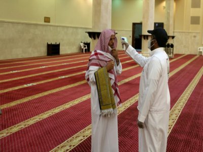 Un bénévole vérifie la température d'un fidèle dans une mosquée à La Mecque, en Arabie saoudite, le 21 juin 2020 - - [AFP]