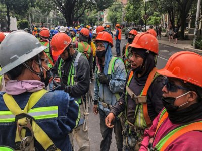 Des travailleurs du bâtiment se rassemblent dans la rue de Mexico lors d'un tremblement de terre le 23 juin 2020 - Pedro PARDO [AFP]
