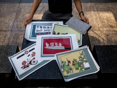 Le caricaturiste de Hong Kong Wong Kei-kwan pose avec ses dessins le 20 juin 2020 - ISAAC LAWRENCE [AFP]