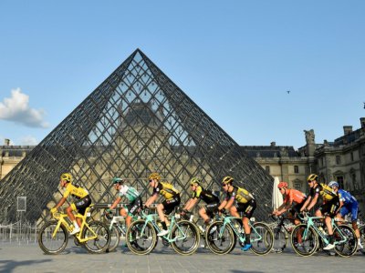 Le Tour de France, qui passe ici au Musée du Louvre lors de son ultime étape, le 28 juillet 2019, fera défaut aux grilles estivales des radios et télés françaises - Julien DE ROSA [POOL/AFP/Archives]