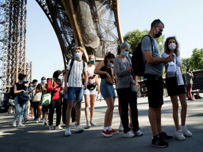 Des personnes font la queue pour visiter à la Tour Eiffel, le jour de sa réouverture, le 25 juin 2020 à Paris - Thomas SAMSON [AFP]