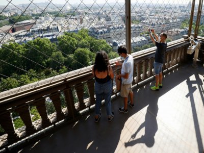 Des visiteurs admirent la vue sur Paris depuis la Tour Eiffel, le jour de sa réouverture, le 25 juin 2020 - Thomas SAMSON [AFP]