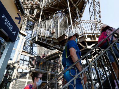 Des visiteurs montent les escaliers de la Tour Eiffel, le jour de sa réouverture, le 25 juin 2020 à Paris - Thomas SAMSON [AFP]