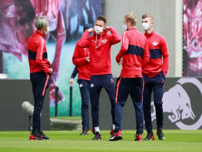 Des joueurs de Leipzig portant des masques à l'échauffement avant d'affronter Paderborn le 6 juin 2020 - HANNIBAL HANSCHKE [POOL/AFP/Archives]
