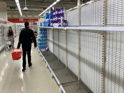 Un client marche entre les rayons destinés au papier toilette dans un supermarché à Melbourne le 26 juin 2020 - William WEST [AFP]