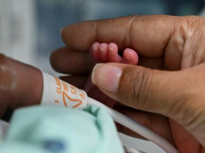 Diana Angola, atteinte par le coronavirus, caresse le pied de son fils Jefferson à la clinique de Versalles, le 23 juin 2020 à Cali, en Colombie - Luis ROBAYO [AFP]