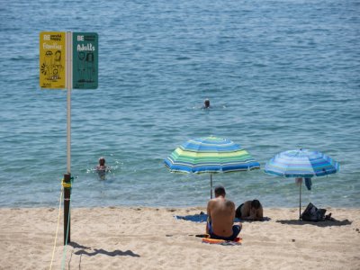 Un panneau indique les espaces réservés aux adultes et aux familles sur la plage de Lloret de Mar, le 22 juin 2020 en Espagne - Josep LAGO [AFP]