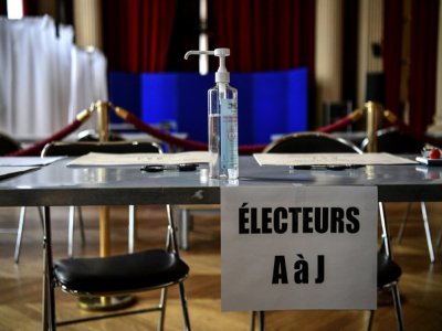 Du gel hydroalcoolique sur une table d'émargement dans un bureau de vote à Paris, le 13 mars 2020, deux jours avant le premier tour des municipales - Christophe ARCHAMBAULT [AFP/Archives]