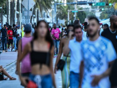 Des promeneurs sur Ocean Drive, le 26 juin 2020 à Miami Beach, en Floride - CHANDAN KHANNA [AFP]