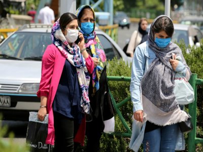 Des Iraniennes portent un masque de protection dans une rue de Téhéran, le 28 juin 2020 - ATTA KENARE [AFP]