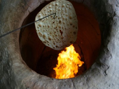 Du pain taftoun en train d'être cuit dans le four traditionnel d'une boulangerie à Téhéran, le 13 juin 2020 - ATTA KENARE [AFP]