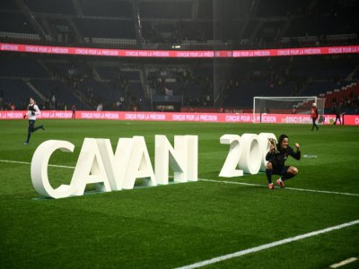 Edinson Cavani pose avec un trophée célébrant son 200e but sous les couleurs du Paris SG après un match contre Bordeaux le 23 février 2020 au Parc des Princes - Martin BUREAU [AFP/Archives]