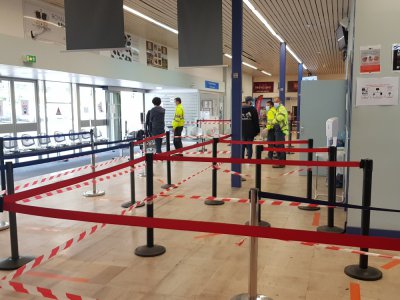Les équipes de l'aéroport mettent en place un sens de circulation avant de passer au contrôle des bagages.
