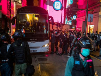 Des policiers arrêtent des manifestants contre la loi sur la sécurité imposée par la Chine et les font monter dans un bus, le 1er juillet 2020 à Hong Kong - DALE DE LA REY [AFP]