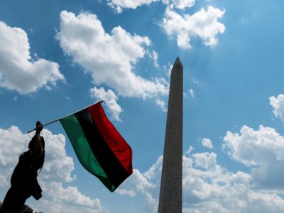 Une manifestante anntiraciste brandit un drapeau aux couleurs du panafricanisme le 4 juillet 2020 à Washington - ROBERTO SCHMIDT [AFP]