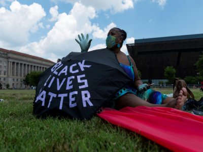 une femme arbore un parapluie "Black Lives Matter" le 4 juillet 2020 à Washington - ROBERTO SCHMIDT [AFP]