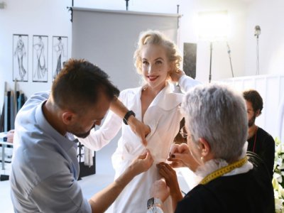 Julien Fournié et sa première couturière, Madame Jacqueline, ajustent une robe sur le mannequin Michaela Tomanova, le 30 juin 2020 à Paris - FRANCK FIFE [AFP]