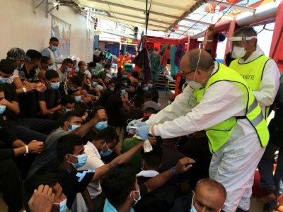 Distribution de bracelets de reconnaissance aux migrants à bord de l'Ocean Viking, le 5 juillet 2020 - Shahzad ABDUL [AFP]