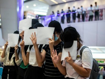 Des manifestants brandissent des feuilles blanches en signe d protestation contre la nouvelle loi sécuritaire chinoise, à Hong Kong, le 6 juillet 2020 - ISAAC LAWRENCE [AFP]
