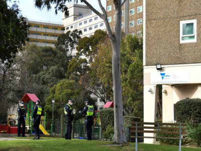 Des policiers devant un immeuble confiné à Melbourne (Australie) le 6 juillet 2020 - William WEST [AFP]