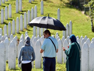 Une famille musulmane prie devant les tombes de proches à Potocari, près de Srebrenica, le 10 juillet 2020 - ELVIS BARUKCIC [AFP]