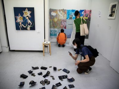 Des visiteurs regardent et photographient  des oeuvres exposées dans la galerie d'art Same où le vol des oeuvres est permis, le 9 juillet 2020 à Tokyo - Behrouz MEHRI [AFP]