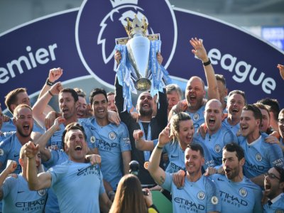 Manchester City et son entraîneur Pep Guardiola soulevant le trophée de Premier League, à Brighton le 12 mai 2019 - Glyn KIRK [AFP/Archives]