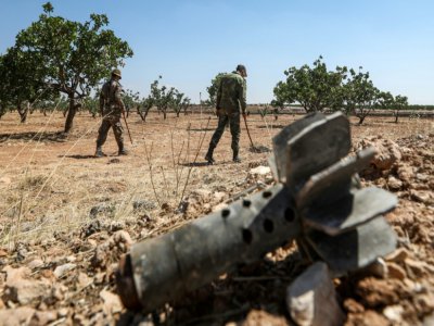 Des soldats de l'armée vsyrienne passent dans les plantations avec des détecteurs pour repérer les mines, aux environ du village de Maan, le 24 juin 2020 - LOUAI BESHARA [AFP]