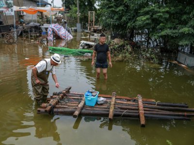 Radeau qui aide les habitants à se déplacer dans les rues du village inondées, près du lac de Poyang, dans le centre de la Chine, le 16 juillet 2020 - STR [AFP]