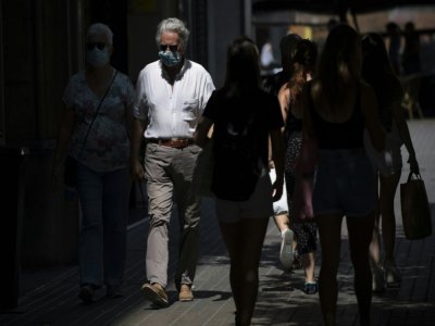 Des promeneurs portent des masques dans les rues de Barcelone, le 18 juillet 2020 - Josep LAGO [AFP]