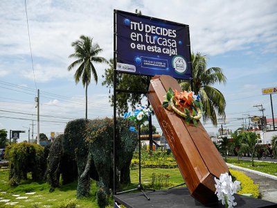 Une pancarte clame "Tu décides: à la maison ou dans cette boîte" à Escuintla, Guatemala, le 21 juillet 2020. - Johan ORDONEZ [AFP]