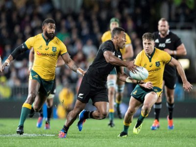Le All Black Seva Reece tente de semer les Wallabies Marika Koroibete et James O'Connor lors d'un match de Rugby Championship, le 17 août 2019 à Auckland - Greg Bowker [AFP/Archives]