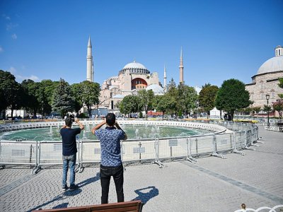Deux passants prennent des photos de Sainte-Sophie à Istanbul le 23 juillet 2020 - Ozan KOSE [AFP]