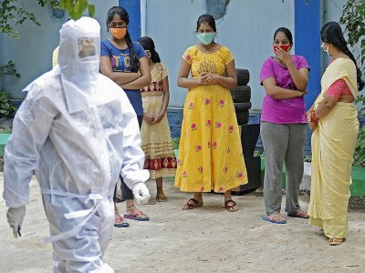 Un soignant et des personnes attendant d'être testées au Covid-19, dans la banlieue de Hyderabad (centre), le 24 juillet 2020 - NOAH SEELAM [AFP]