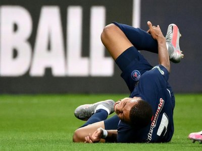 L'attaquant du Paris SG Kylian Mbappé se tient la cheville droite après avoir subi une faute lors de la finale de Coupe de France contre Saint-Etienne le 24 juillet 2020 au Stade de France à Saint-Denis - FRANCK FIFE [AFP]