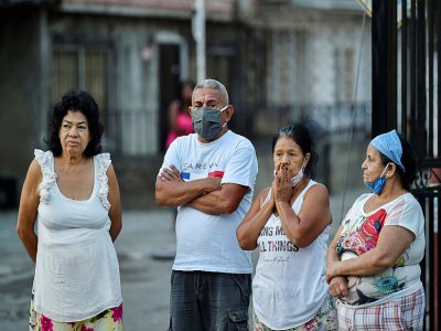 Des riverains observent des employés de pompes funèbres emporter le corps d'un homme probablement décédé du Covid-19, à Cali (Colombie), le 26 juillet 2020 - Luis ROBAYO [AFP]