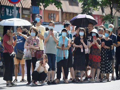 Un flot de curieux prennent des photos depuis une route menant au consulat américain de Chengdu, dans la province du Sichuan, dans le sud-ouest de la Chine, le 27 juillet 2020 - Noel Celis [AFP]