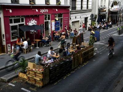 Des personnes prennent un verre à la terrasse élargie d'un bar à Paris, le 23 juillet 2020 - Christophe ARCHAMBAULT [AFP]