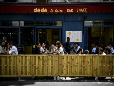 Des personnes déjeunent à la terrasse élargie d'un bar à Paris, le 23 juillet 2020 - Christophe ARCHAMBAULT [AFP]