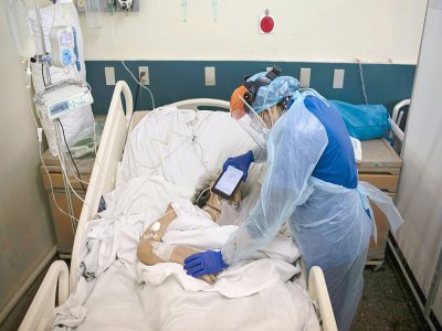Le docteur Moyra Lopez fait écouter via un iPad un message d'adieu de ses proches à un patient en soins palliatifs à l'hôpital Barros Luco à Santiago, au Chili - Martin BERNETTI [AFP]