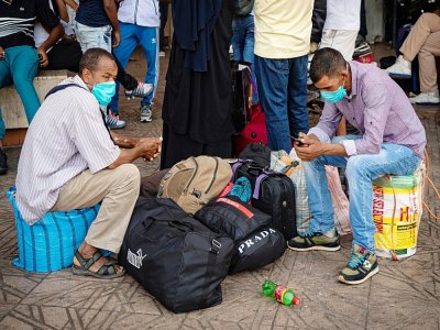 Des Marocains attendent à la station de bus "Ouled Ziane" à Casablanca le 27 juillet 2020 pour quitter la ville avant l'entrée en vigueur de la restriction des déplacements - FADEL SENNA [AFP]