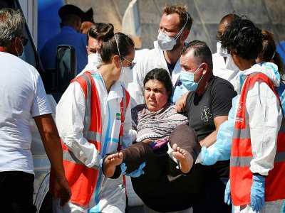 Des migrants arrivent au port de Lampedusa, le 29 juillet 2020 après avoir été secourus par des gardes-côtes italiens en Méditerranée - Alberto PIZZOLI [AFP]