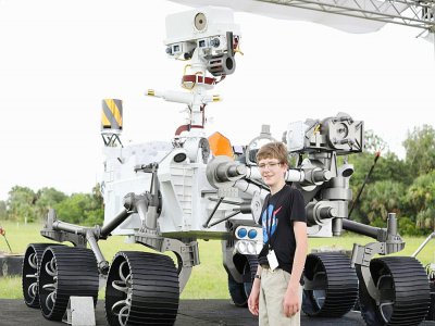 Alex Mather, 13 ans, qui a proposé le nom de Perseverance à la Nasa, pose à côté d'une maquette grandeur nature du rover, le 28 juillet 2020 à Cap Canaveral, en Floride - Gregg Newton [Gregg Newton/AFP]