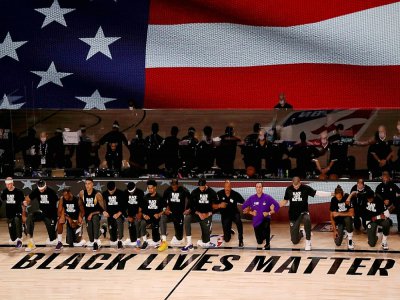 Membres des Los Angeles Lakerset des LA Clippers agenouillés devant le mot d'ordre "Black lives matter" et durant l'hymne américain avant leur match de NBA, le 30 juillet 2020 à Lake Buena Vista (Floride) - Mike Ehrmann [GETTY IMAGES NORTH AMERICA/AFP]